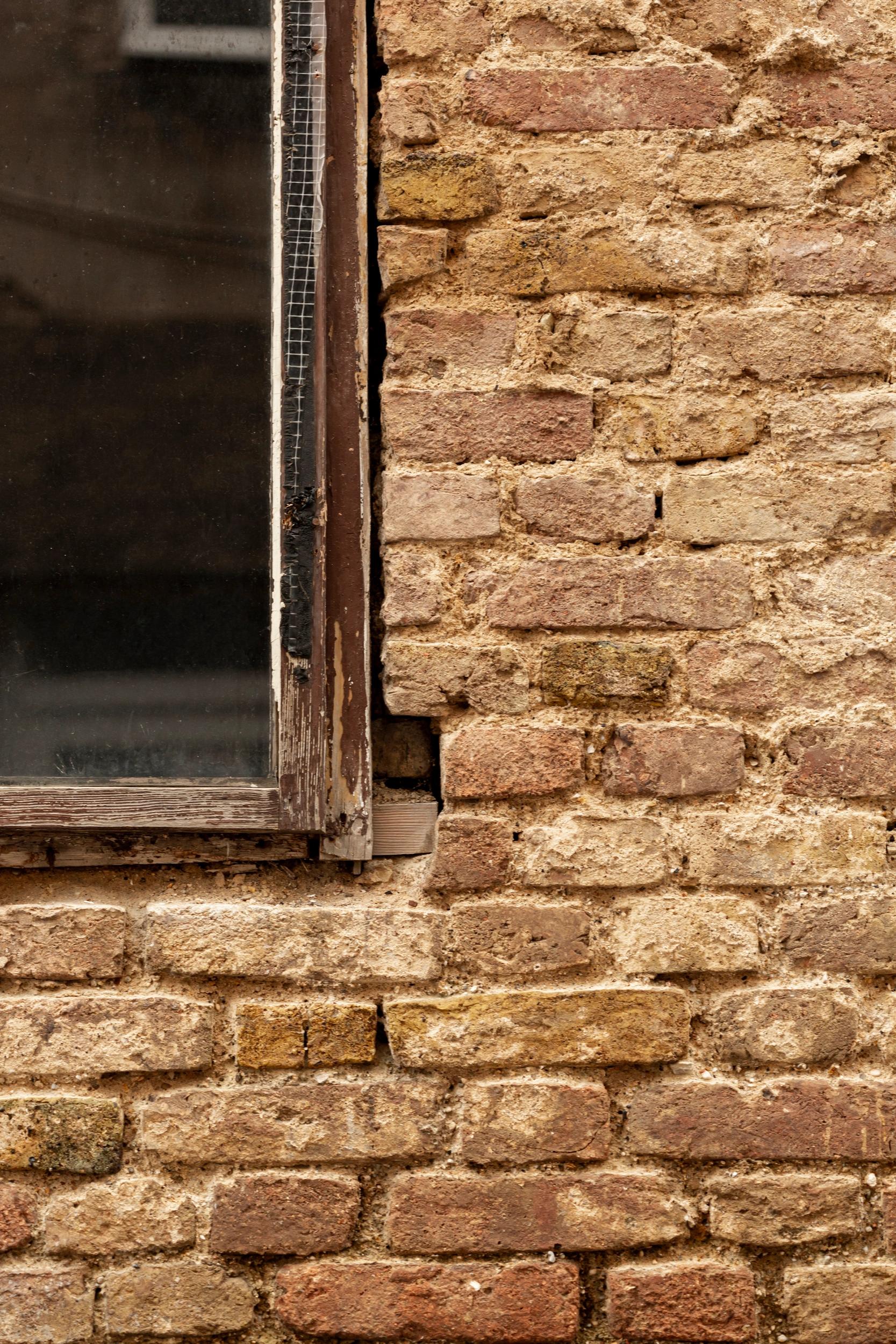 Fenêtre en bois sur mur en pierre de l'hôtel San Andrea 