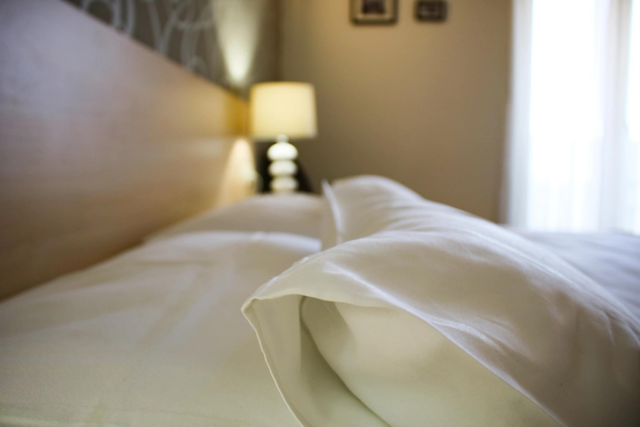 Lit et lampe de chevet dans une chambre de l'hôtel 4 étoiles San Andrea